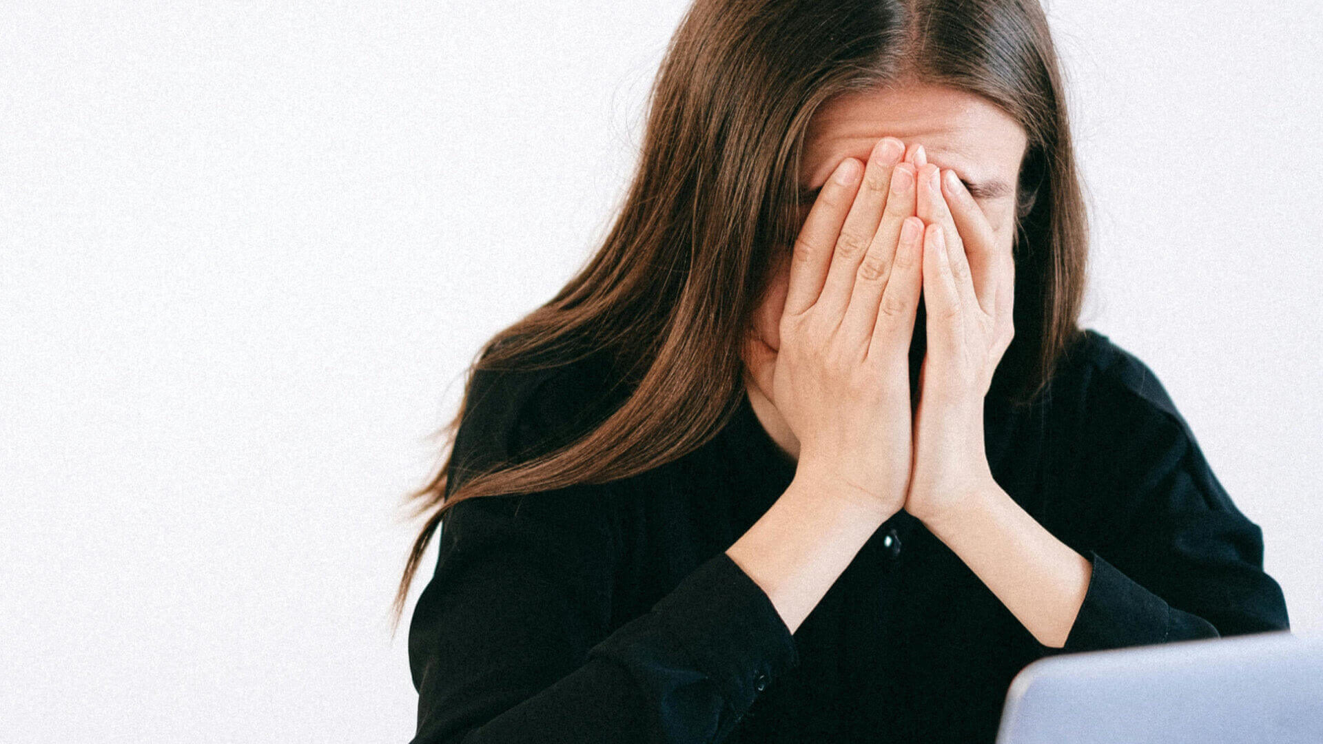 Demotivation erkennen. Frau sitzt mit Händen vors Gesicht geschlagen vor dem PC.