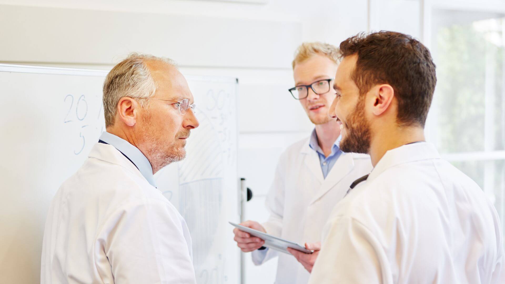 Selbstorganisation als Führungsaufgabe 2 Ärztliches Team in einer Besprechung als Symbol für Führungsspielraum, Abstimmung und klare Entscheidungen im Gesundheitswesen