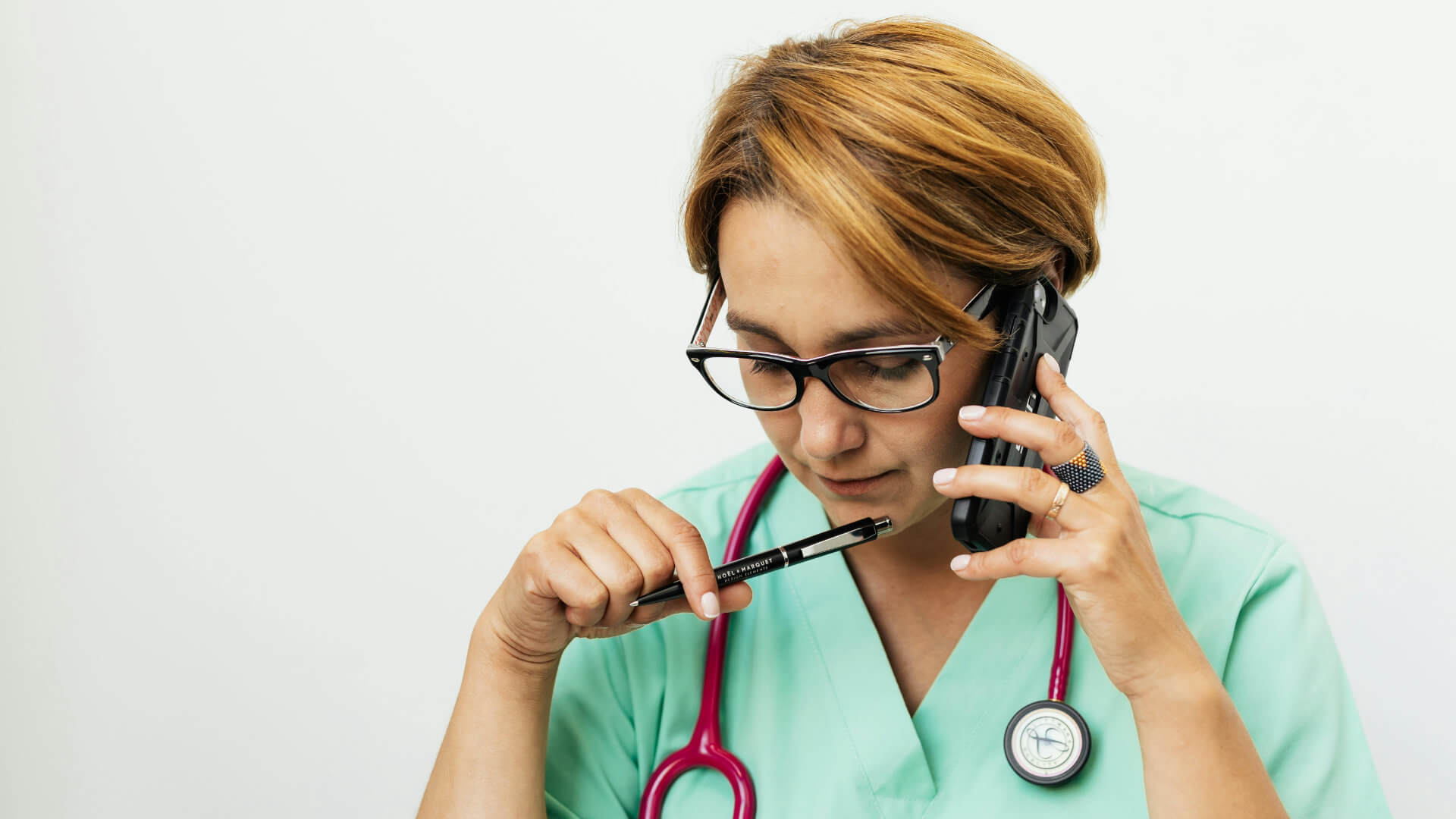 Medizinische Fachperson telefoniert konzentriert als Symbol für Kommunikation und Konfliktklärung im Gesundheitswesen.